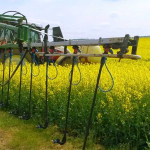 Pflanzenschutzspritze mit Dropleg-Technologie auf einem blühenden Rapsfeld
