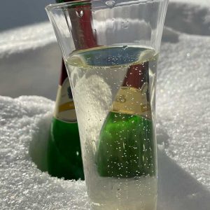 Sektflasche mit Glas im Schnee