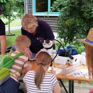 Kinder beobachten beim Besuchertag Pflanzenschädlinge unter dem Binocular