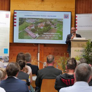 Daniel Köfer hält einen Vortrag in der ALB-Halle am Eichhof, im Vordergrund sind Gäste zu sehen