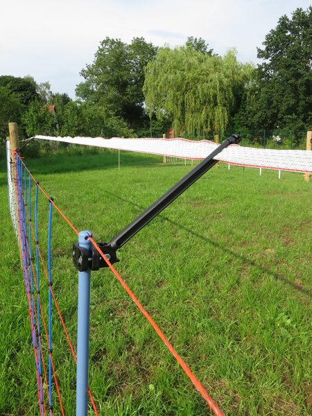 Herdenschutzzaun an einer Wiese, im Hintergrund Bäume