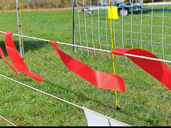 Rote Flatterbänder an einem Herdenschutzzaun