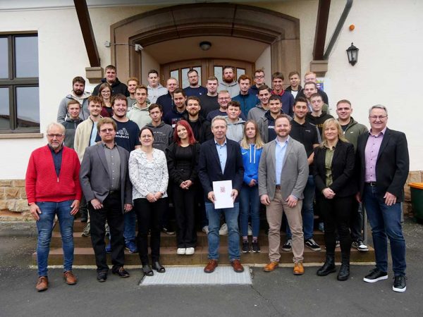 Gruppenfoto mit Studierenden und Lehrkräften vor dem Eingangsbereich der Fachschule Alsfeld