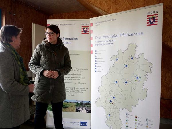 2 Personen im Gespräch stehen vor Flipcharts