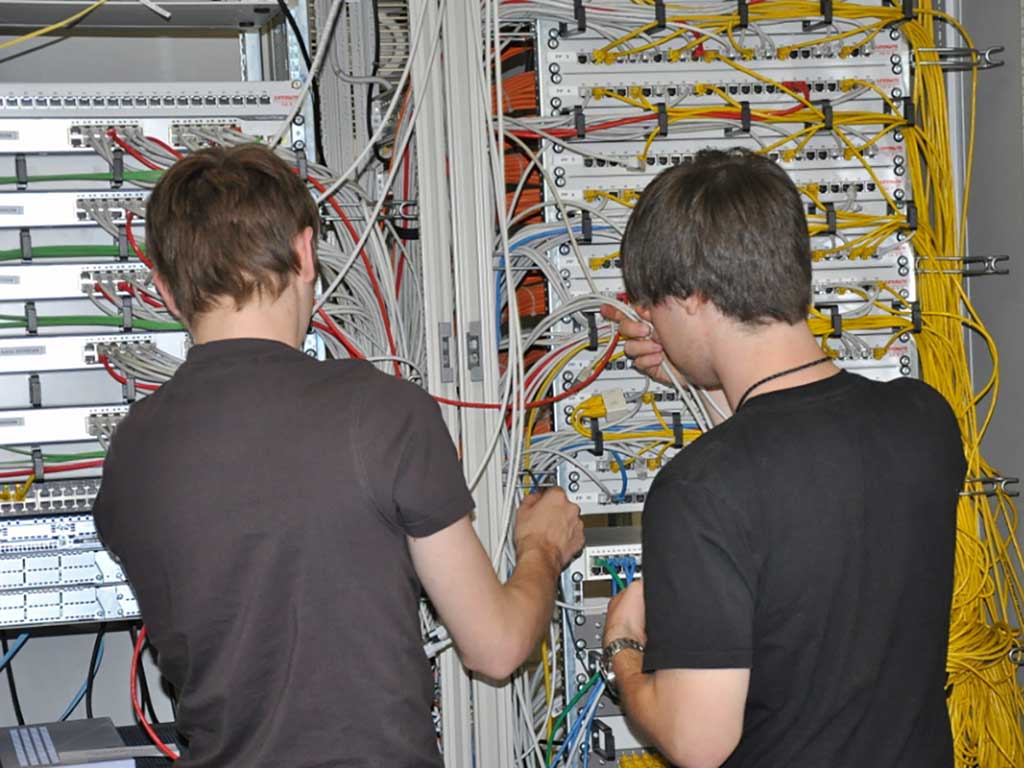 2 auszubildende Fachinformatiker in einem Serverraum