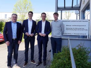 4 Personen stehen vor einem Gebäude