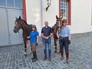 3 Personen stehen vor 2 Pferden