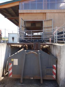 Container in einer Grube vor einem Stall