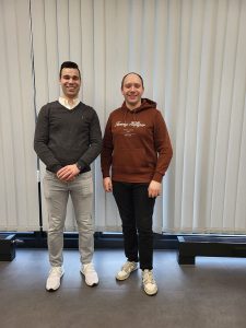 2 männliche Personen stehn in einem Raum