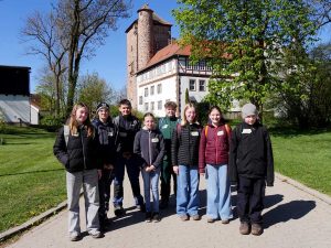 8 Schülerinnen und Schüler stehen vor den Gebäuden des Eichhofs