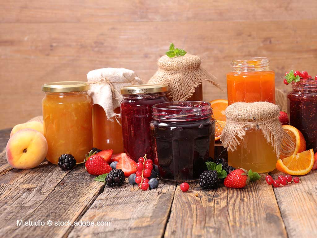 verschieden Marmeldaengläser; davor liegen Früchte