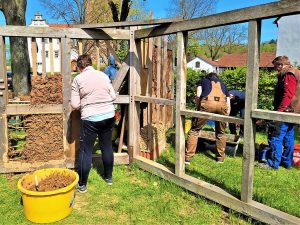 Teilnehmende des Praxis-Workshops „Lehmbau erleben“ am Landwirtschaftszentrum Eichhof arbeiten gemeinsam an einer Lehmbauwand. Unter fachlicher Anleitung werden Lehmbausteine hergestellt und das Ausfachen sowie Verputzen mit Lehm praktisch erprobt.