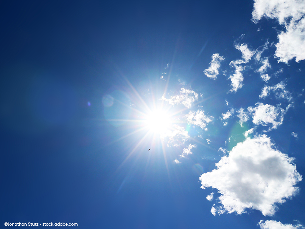 Leicht bewölkter Himmel mit greller Sonne