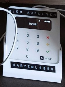 Das Bild zeigt ein weißes, fast quadratisches, etwa handtellergroßes Kartenlesegerät.