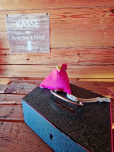 Das Bild zeigt eine Kleingeldkassette in einem Hofladen. Man sieht der Kasse nicht an, dass sie fest auf der Theke installiert ist.